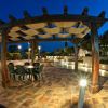 Pergolato con tavolo su terrazza piastrellata di notte.