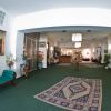 Salone albergo con divano, tappeti e quadri.