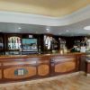 Un bancone bar in legno con specchi e mensole.