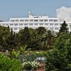 Edificio bianco tra palme e alberi verdi.