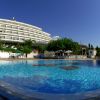 Piscina e hotel circondati da alberi.