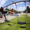 Altalene in un parco giochi con scivolo e divertimenti vari.