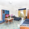 Un monolocale con mobili blu, un letto matrimoniale, un divano e un tavolo da pranzo.