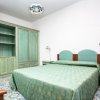 Camera d'albergo con arredamento verde pastello e letto matrimoniale.