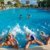 Persone rilassate in piscina, con l'acqua che spruzza intorno a loro.