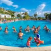 Persone che si divertono in una piscina all'aperto sotto un cielo sereno.