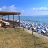 Un ristorante all'aperto vicino a una spiaggia con ombrelloni blu e bianchi.