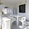 Veranda con tavolo bianco e quattro sedie.