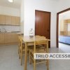 Cucina e sala da pranzo accessibile con tavolo in legno.