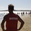Bagnino sulla spiaggia con maglia rossa 