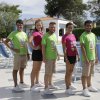 Cinque persone in divisa colorata posano vicino alla piscina.
