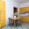 Cucina gialla con tavolo rotondo e fiori.