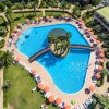 Piscina vista dall'alto con ombrelloni arancioni.
