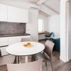 Cucina moderna con tavolo rotondo e quattro sedie.