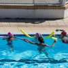 Bambini apprendono a nuotare in piscina.