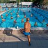 Allenatore davanti a gruppo in acqua in una piscina.