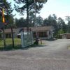 Ingresso di un campeggio con cancelli, bandiere e edificio sullo sfondo.