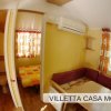 Sala con tavolo, divano e porta che conduce a bagno e camera.