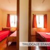 Due camere da letto con letti singoli, coperte rosse.