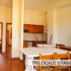 Cucina e sala da pranzo con tavolo bianco e sedie.