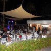 Area lounge esterna affollata sotto una tenda di notte.