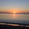 Un tramonto sul mare con la luce del sole che riflette sull'acqua.