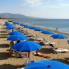 Spiaggia con ombrelloni blu a schiera.