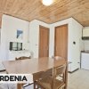 Interno di appartamento con tavolo di legno, porte, e cucina. Parola 