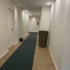 Corridoio d'albergo con moquette blu e pavimento in legno.