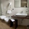 Bagno moderno con lavabo, doccia in vetro, bidet e wc.