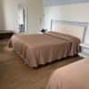 Camera d'albergo con letto matrimoniale e arredo minimalista.