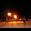 Persone che eseguono uno spettacolo con il fuoco all'aperto di notte.
