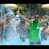 Gruppo di persone che si diverte in una piscina, spruzzando acqua.