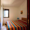 Camera da letto con letto matrimoniale e coperta a righe colorate.