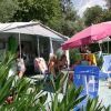 Due ombrelloni e sedie davanti a una tenda, immersi nel verde.
