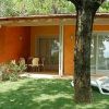 Patio con sedie, prato verde e alberi.