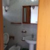 Bagno piccolo con sanitari bianchi e specchio.