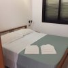 Camera da letto con letto matrimoniale e lenzuola bianche.
