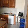 Cucina con mobili in legno, mini frigo e piccola TV.