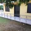 Ingresso di una casa con rampa accessibile e finestre scure.