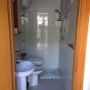 Un piccolo bagno con lavandino, WC e doccia.