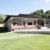 Casa con portico in mattoni e giardino verde.