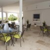 Sala con tavoli, sedie e piante.