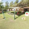 Parco giochi all'aperto con altalena e scivolo.