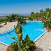 Piscina all'aperto circondata da piante e vista mare.