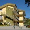 Edificio giallo a tre piani con scale esterne.