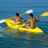 Due persone remano in kayak giallo sull'acqua.