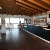 Interno di un bar con soffitto in legno e bancone lungo.