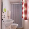 Bagno con lavandino, WC e tende a quadri.