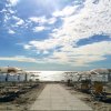 Spiaggia con ombrelloni e mare al tramonto.